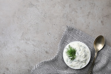 Photo of Cucumber sauce, spoon and space for text on grey background, flat lay. Traditional Tzatziki