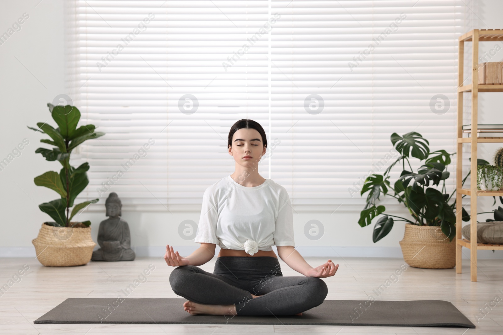 Photo of Beautiful girl meditating on mat in yoga studio