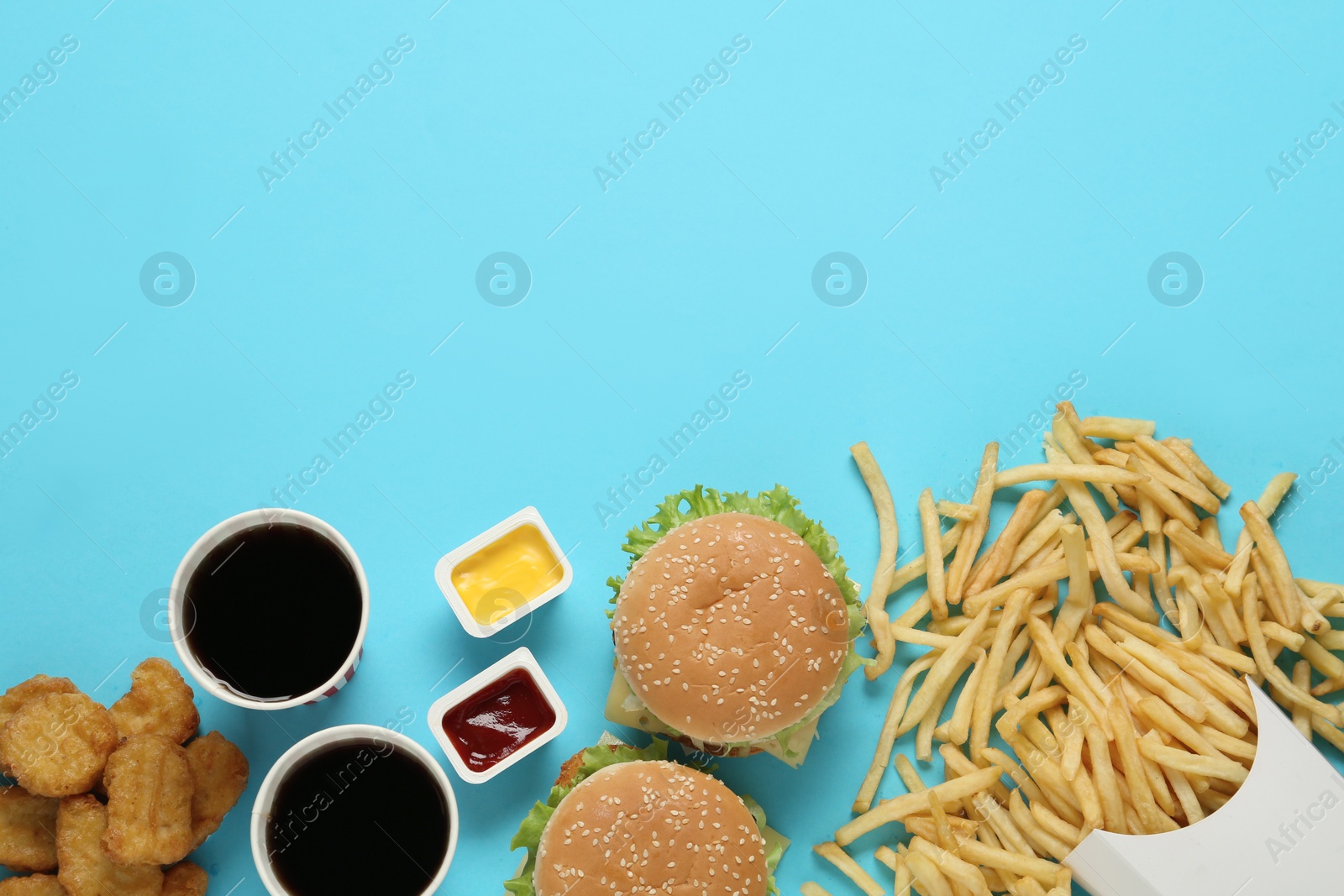 Photo of Flat lay composition with delicious fast food menu on light blue background. Space for text