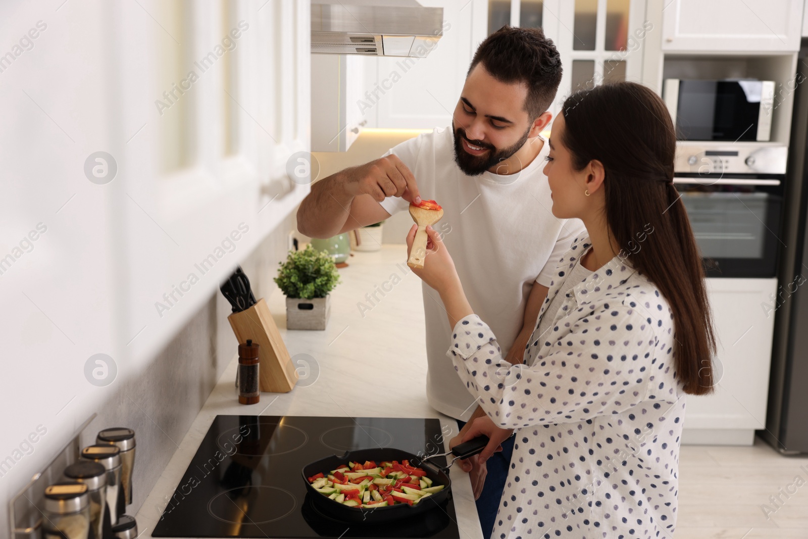 Photo of Happy lovely couple cooking together in kitchen