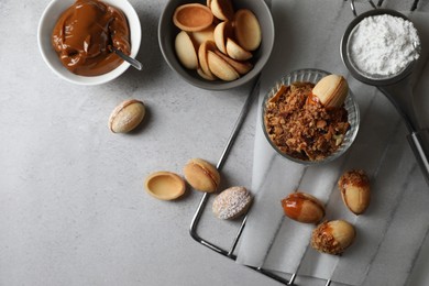 Delicious walnut shaped cookies with condensed milk on grey table, flat lay