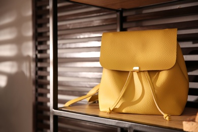 Photo of Stylish woman's bag on shelf in boutique