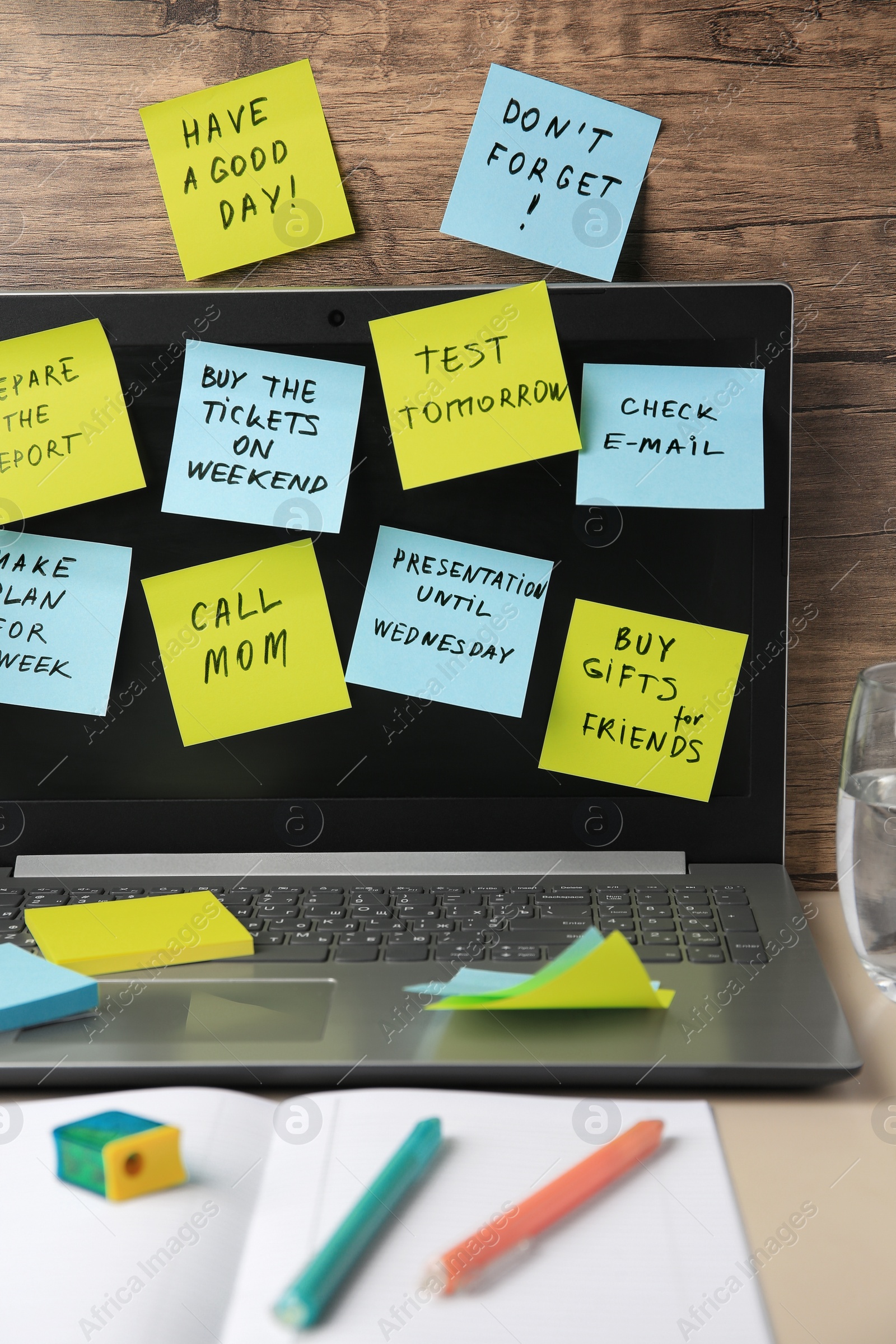 Photo of Many different reminder notes and laptop on table against wooden background