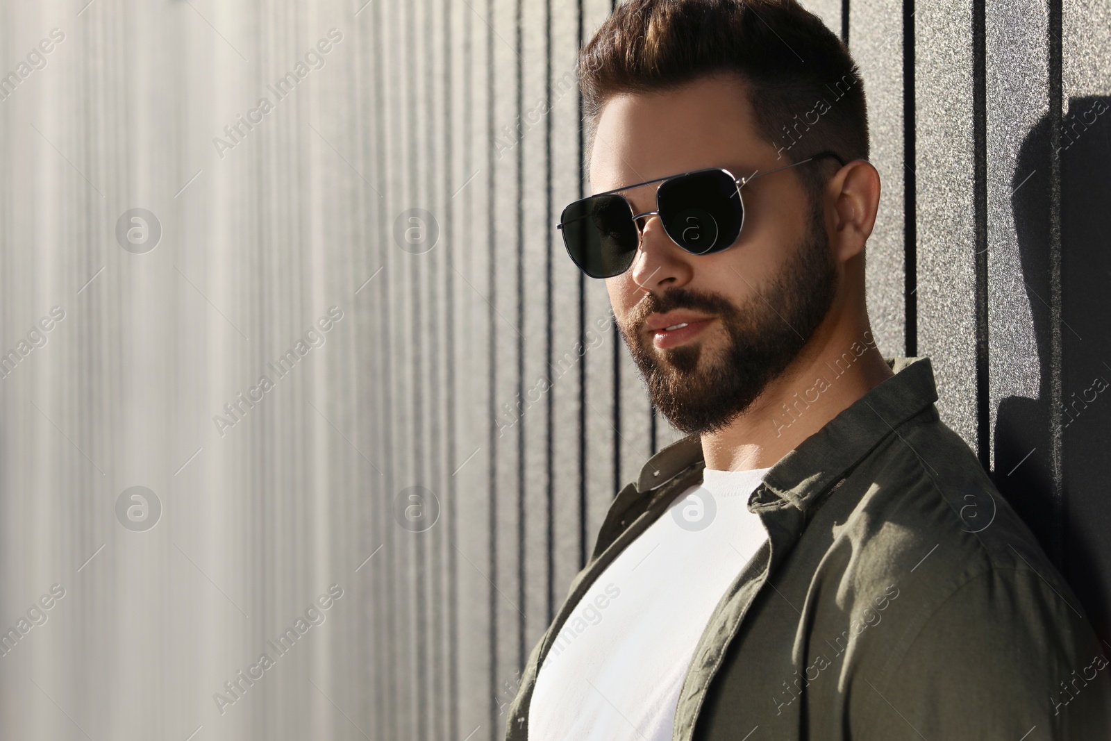 Photo of Handsome man in sunglasses outdoors, space for text