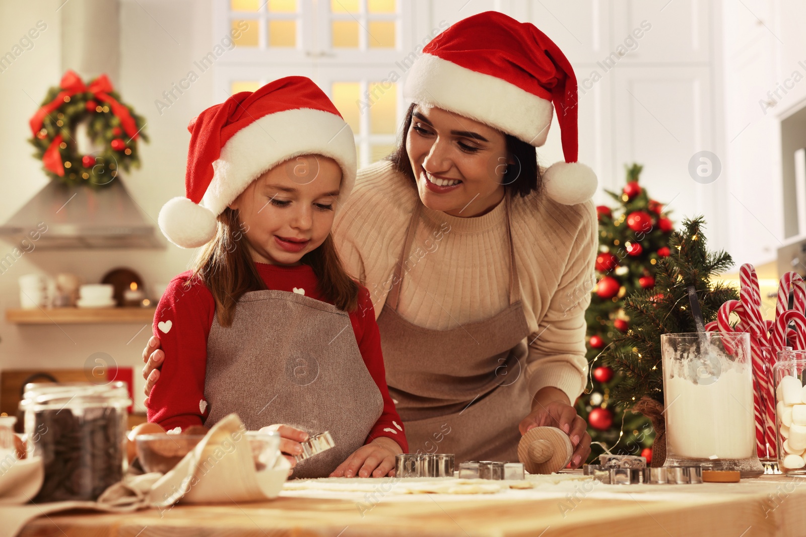 Photo of Happy mother and her daughter making delicious Christmas cookies at home