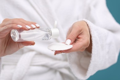 Photo of Woman with makeup remover and cotton pad, closeup