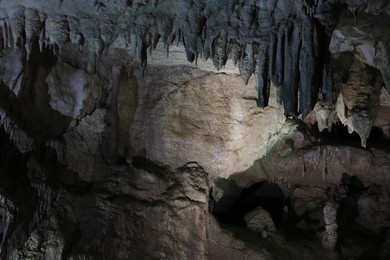 Picturesque view of many stalactite formations in dark cave