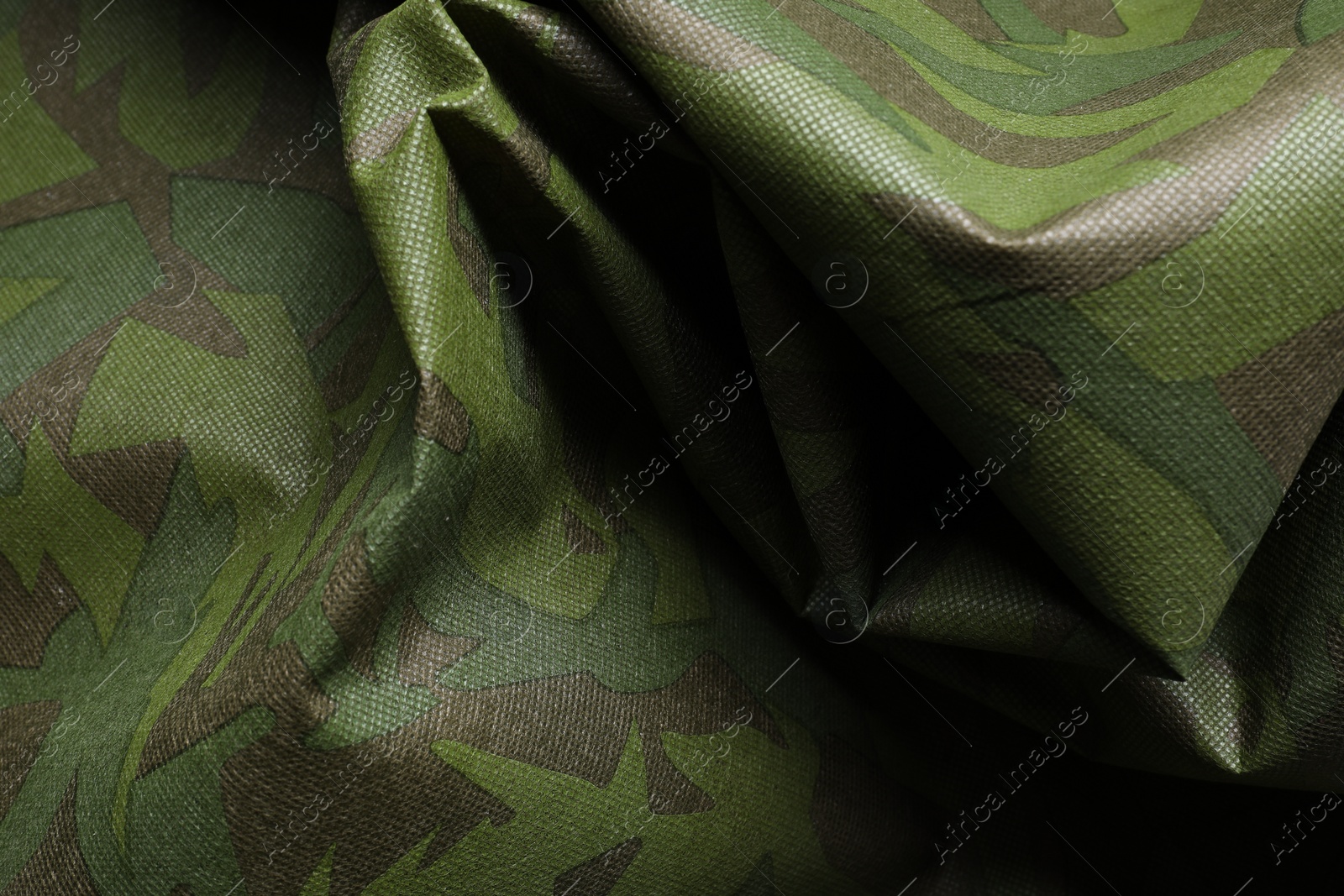 Photo of Texture of crumpled camouflage fabric as background, top view