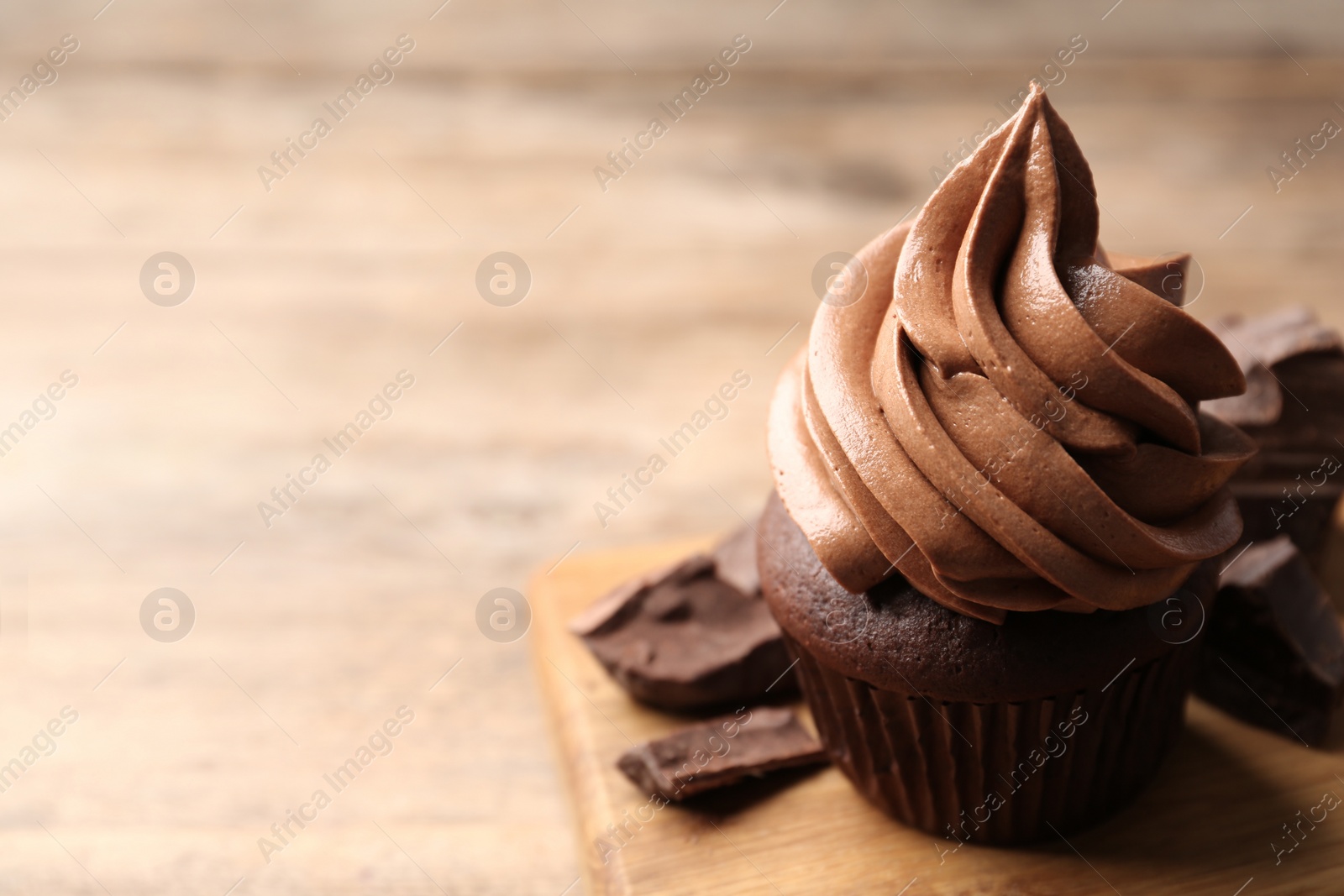 Photo of Delicious chocolate cupcake with cream on table, closeup. Space for text