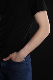 Man with space for tattoo on his arm against black background, closeup