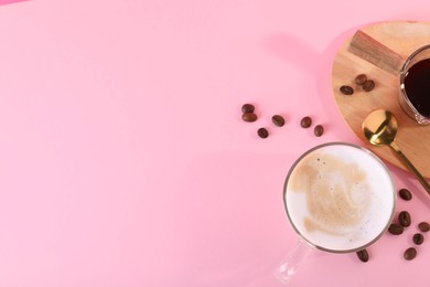 Photo of Cup of fresh coffee and beans on pink table, flat lay. Space for text