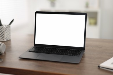 Laptop with blank screen on wooden table indoors, Space for text