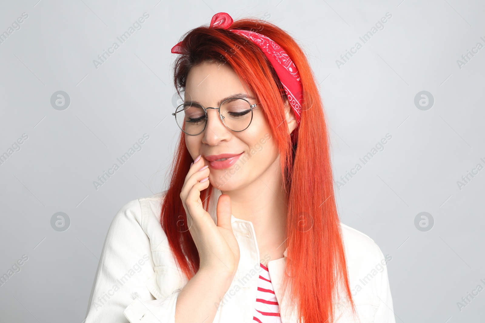 Photo of Young woman with bright dyed hair on grey background