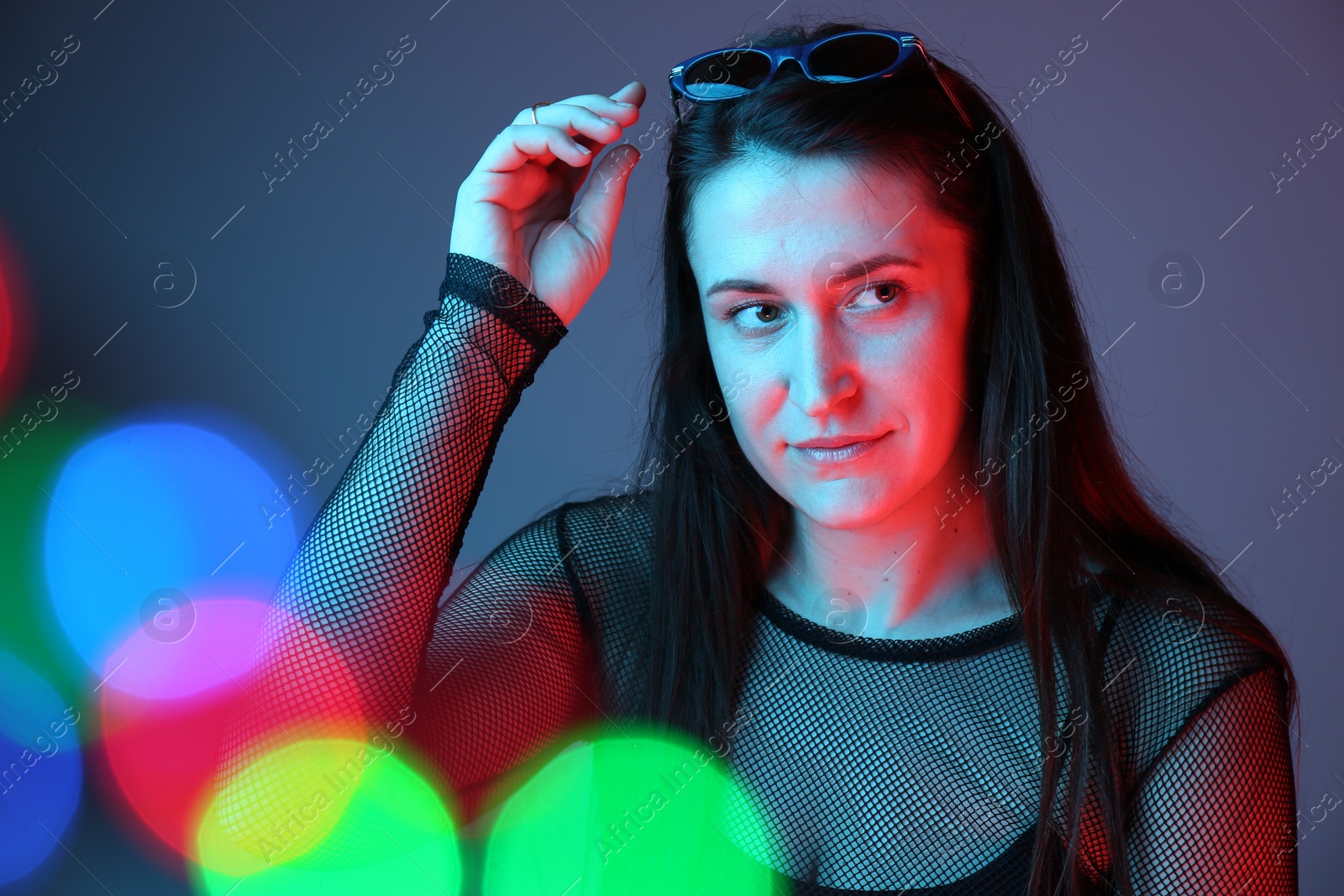 Photo of Portrait of beautiful young woman with sunglasses on color background