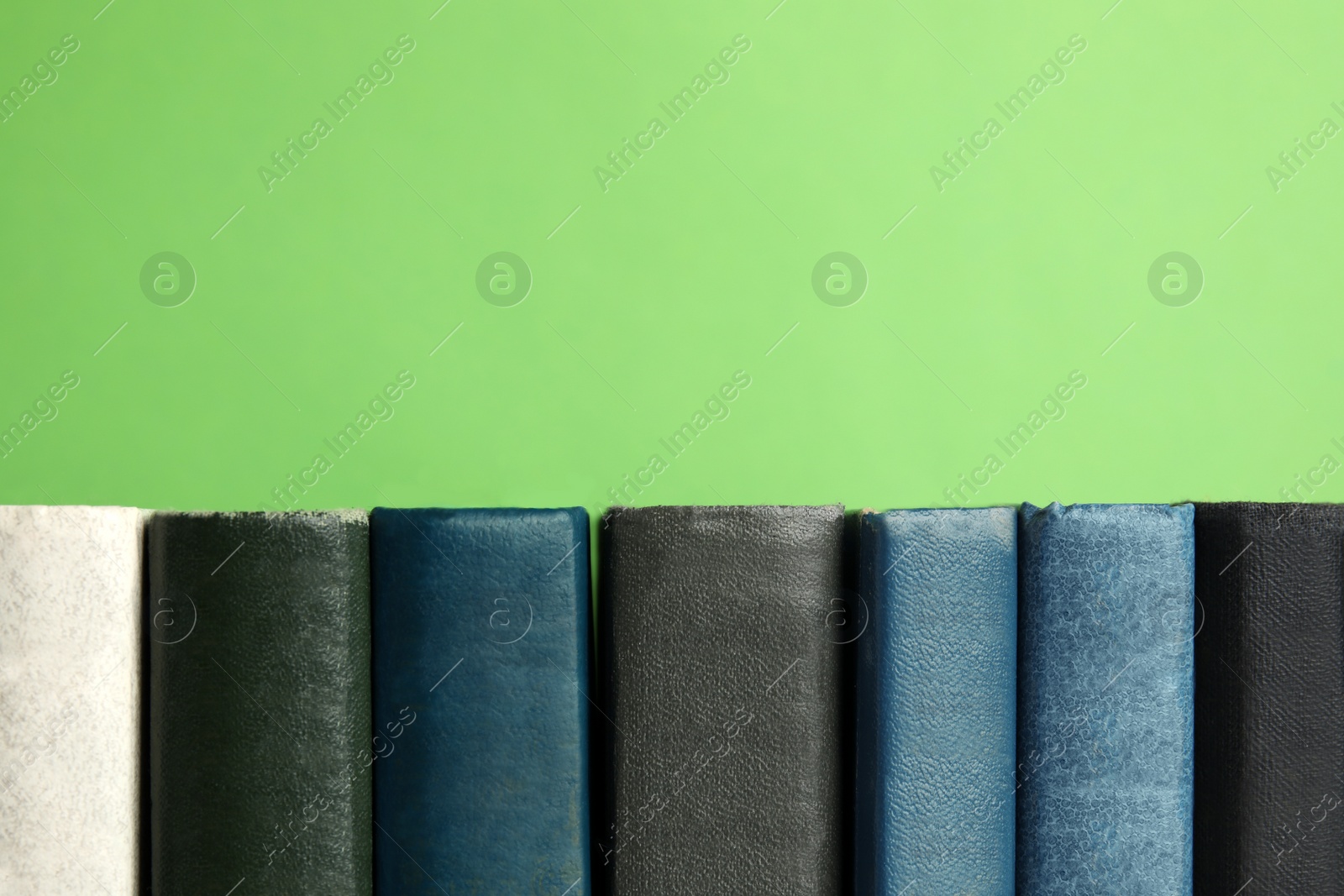 Photo of Collection of old books on green background, space for text