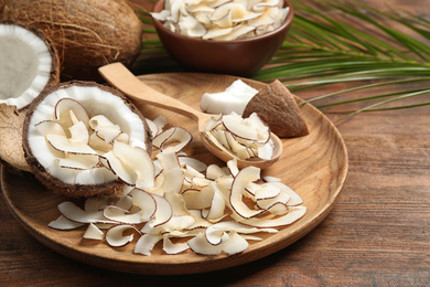 Composition with tasty coconut chips on wooden table