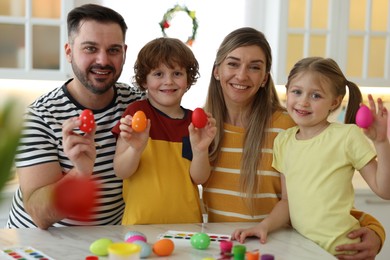 Easter celebration. Portrait of happy family with painted eggs at white marble table in kitchen