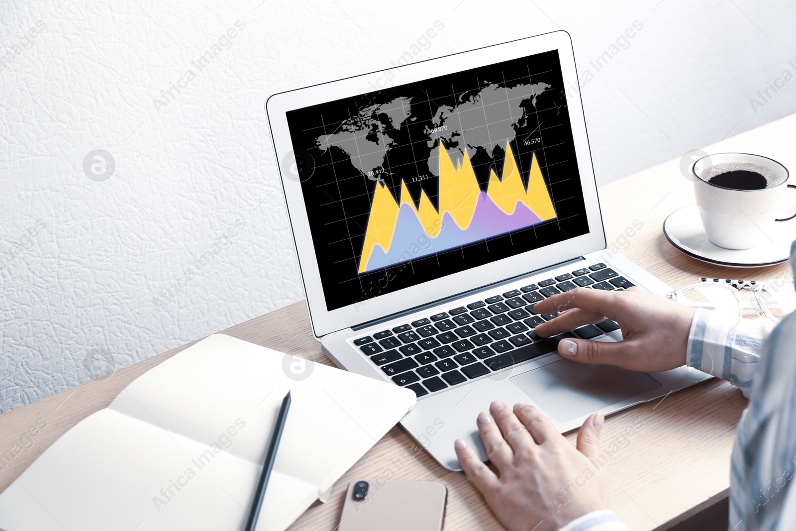 Image of  Broker working with laptop at table, closeup. Forex trading