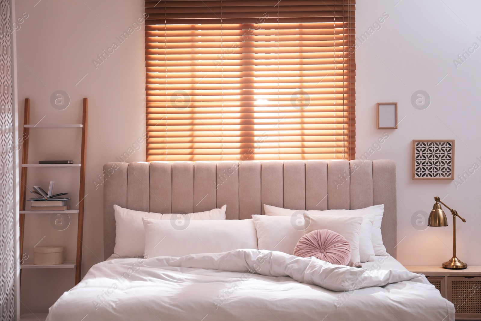 Photo of Cozy bed with soft linens in light room