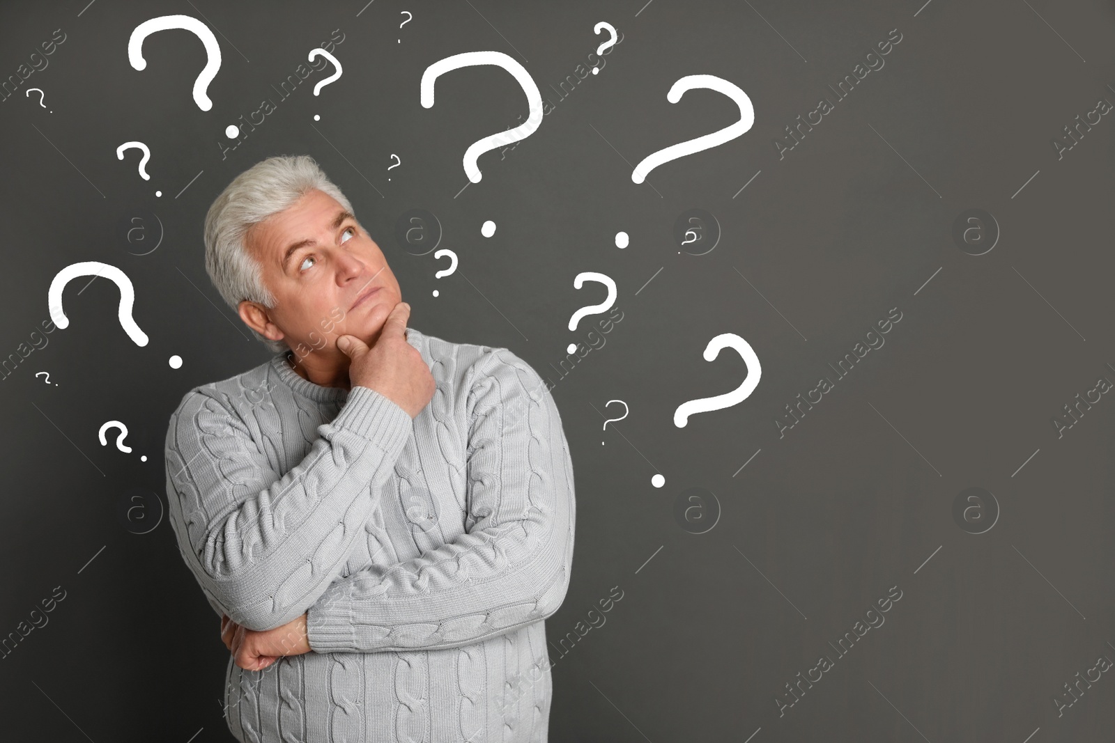 Image of Emotional senior man with drawings of question marks on grey background