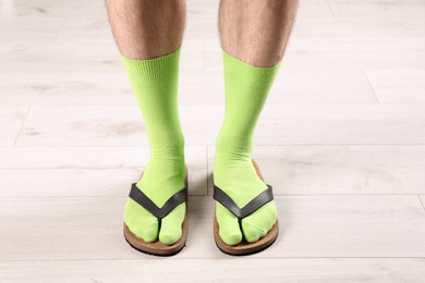 Photo of Man in socks and slippers on floor, closeup
