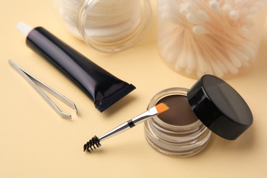 Photo of Eyebrow henna and tools on beige background