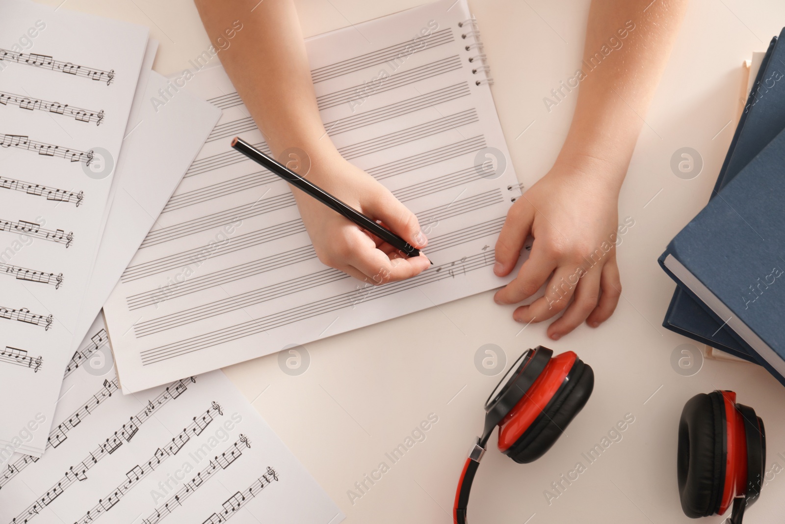 Photo of Child writing music notes at table, top view