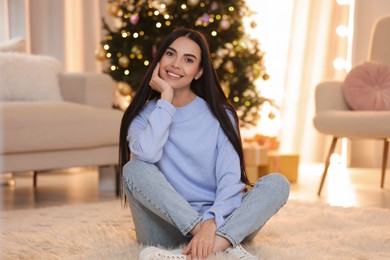 Beautiful young woman in room decorated for Christmas