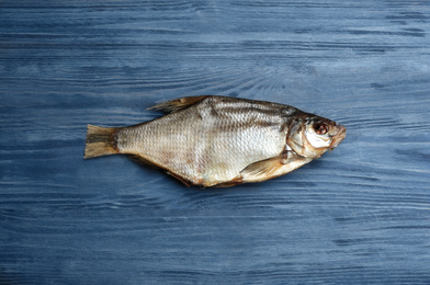 Tasty dried fish on blue wooden table, top view