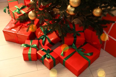 Many beautifully wrapped gift boxes under Christmas tree indoors, above view