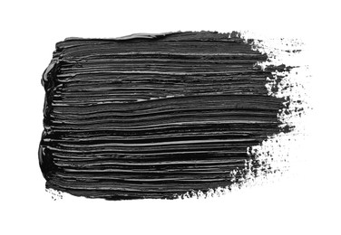 Photo of Brushstrokes of black oil paint on white background, top view
