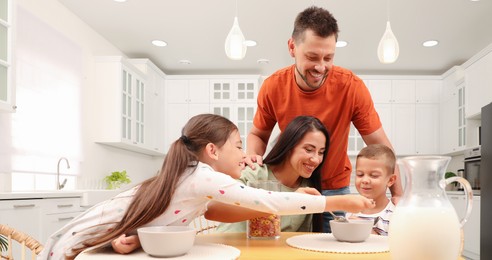 Image of Happy family with children having fun during breakfast at home. Banner design