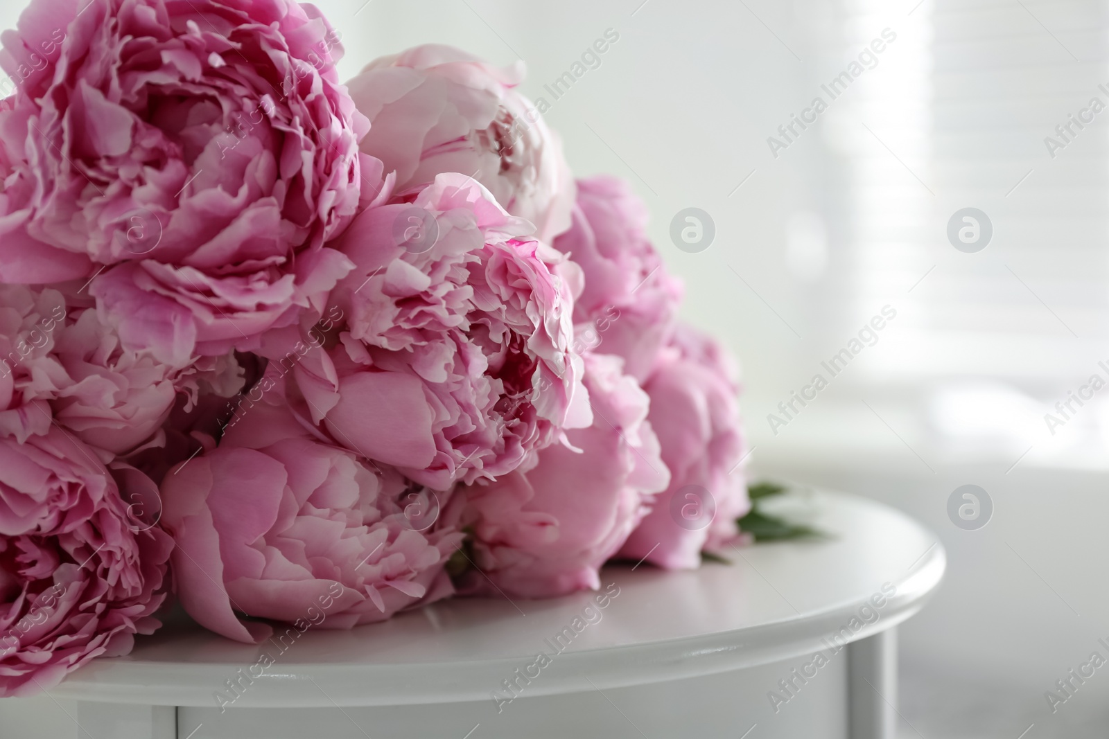 Photo of Bunch of beautiful peonies on table indoors, closeup
