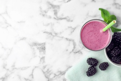 Photo of Delicious blackberry smoothie in glass on marble table, top view. Space for text