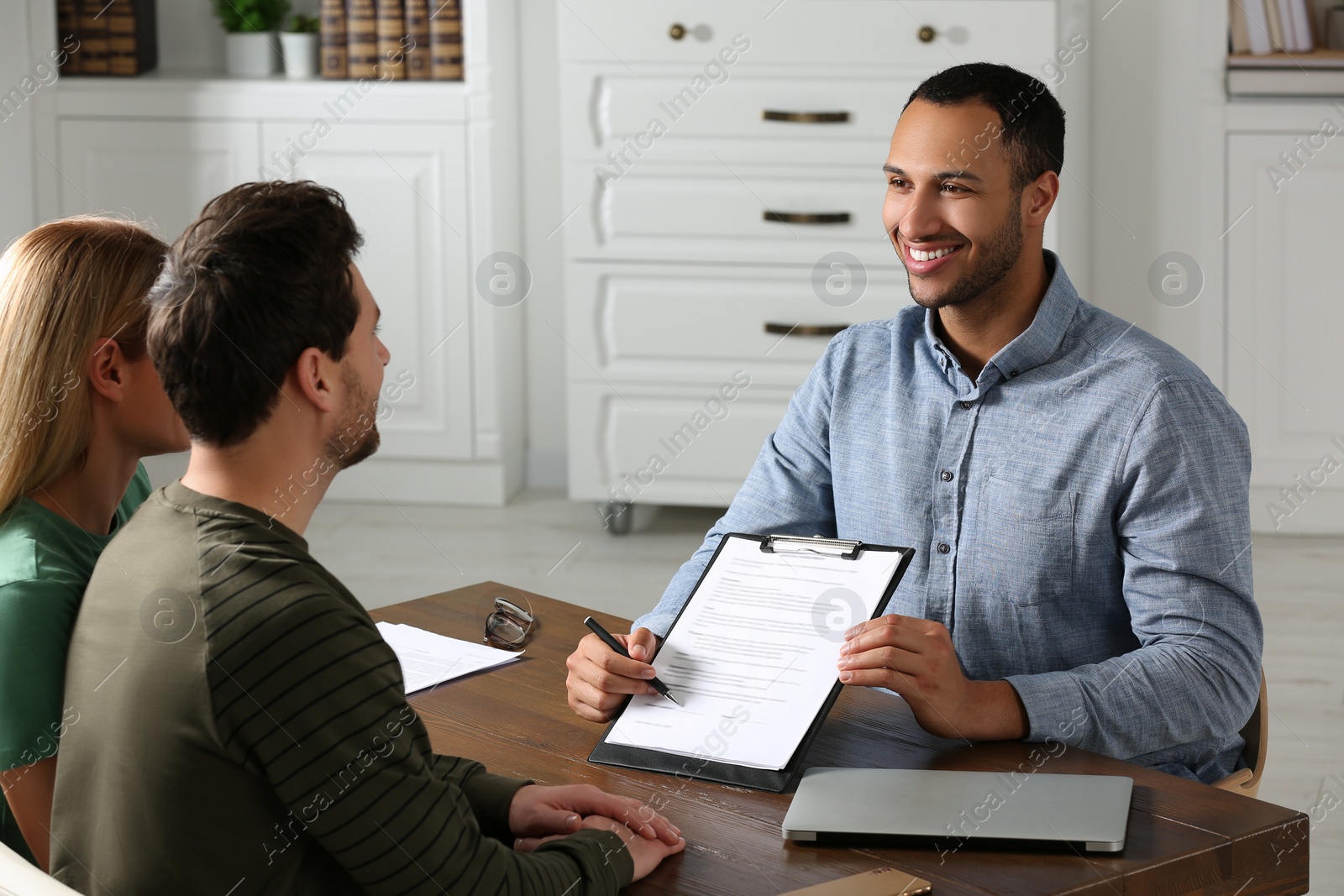 Photo of Notary showing contract to couple in office