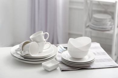 Photo of Set of clean dishware on white table indoors