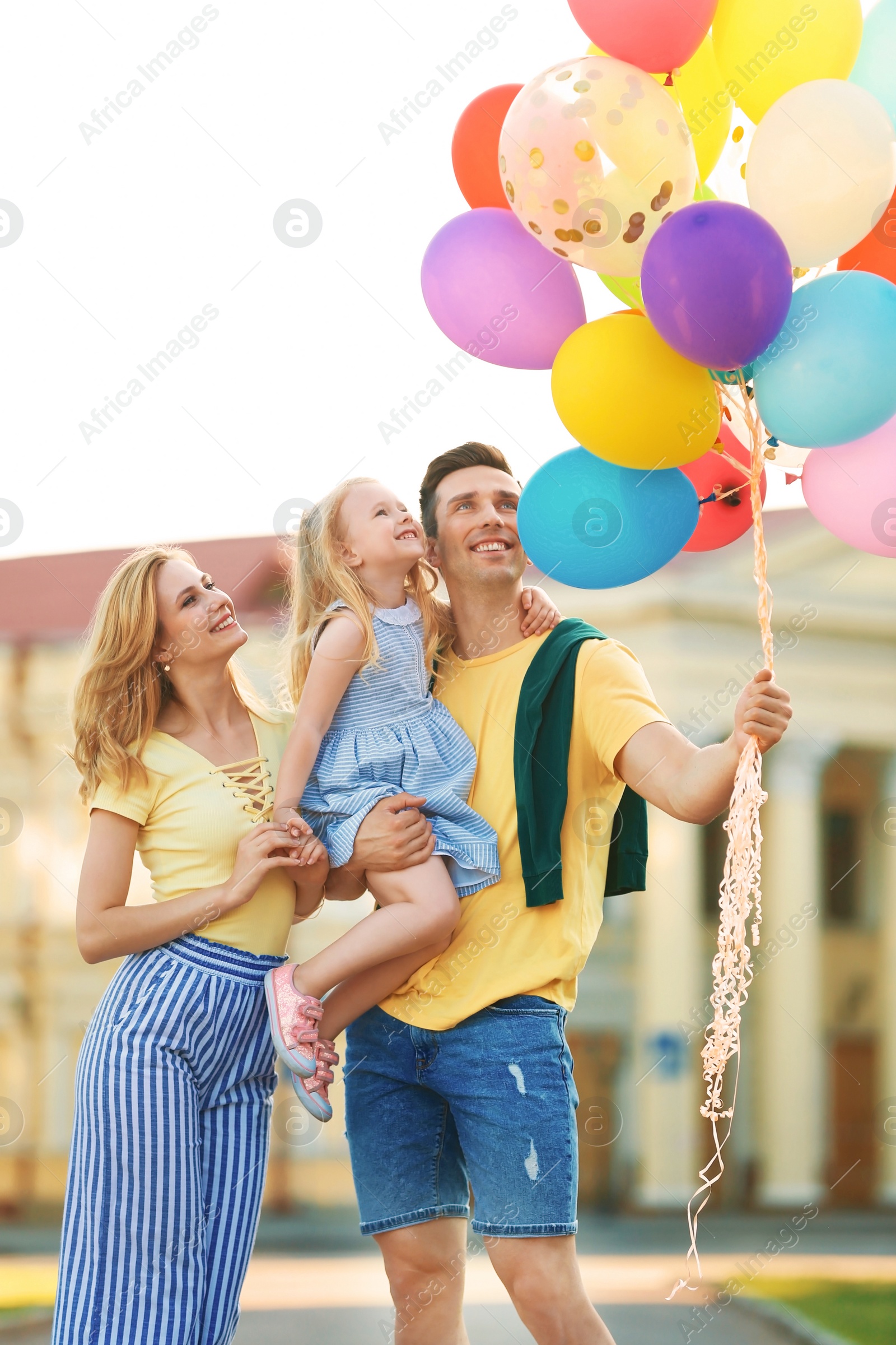 Photo of Happy family with colorful balloons outdoors on sunny day