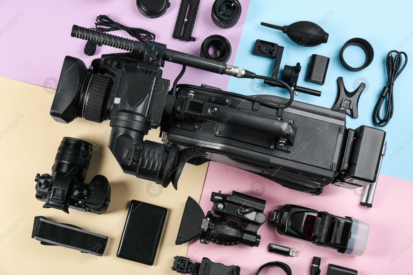 Photo of Flat lay composition with video camera and other equipment on color background