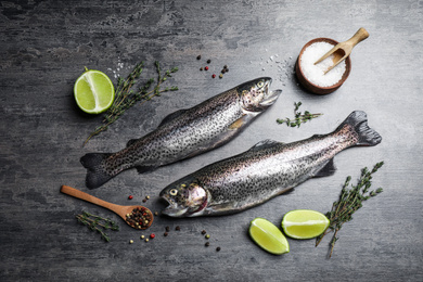 Flat lay composition with raw cutthroat trout fish on grey table