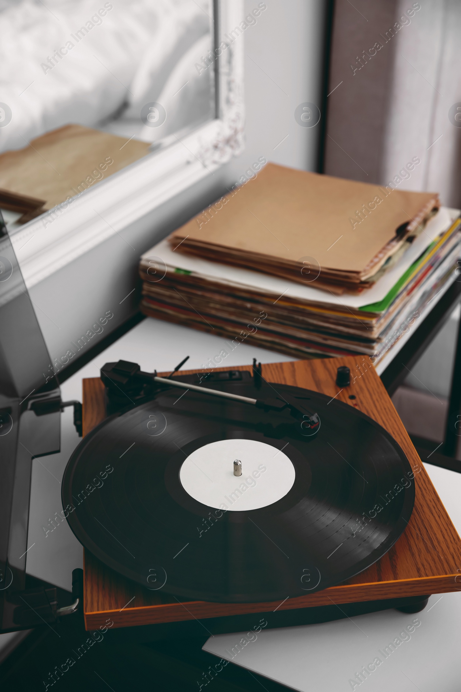 Image of Stylish turntable with vinyl record on table indoors