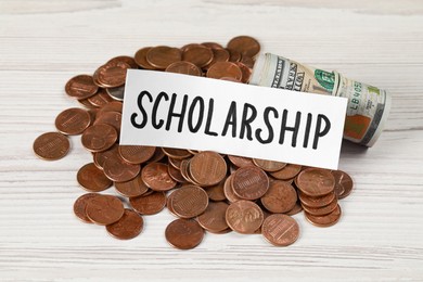 Photo of Sheet of paper with word Scholarship, coins and dollar banknotes on white wooden table
