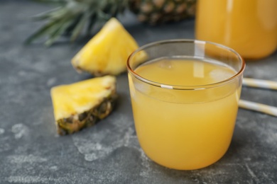 Glass with delicious pineapple juice on table