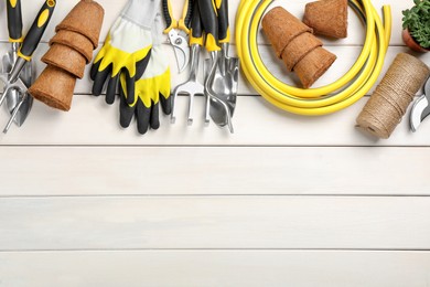 Photo of Flat lay composition with gardening tools on white wooden background, space for text