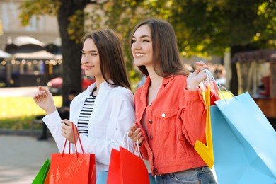 Photo of Beautiful young women with shopping bags on city street