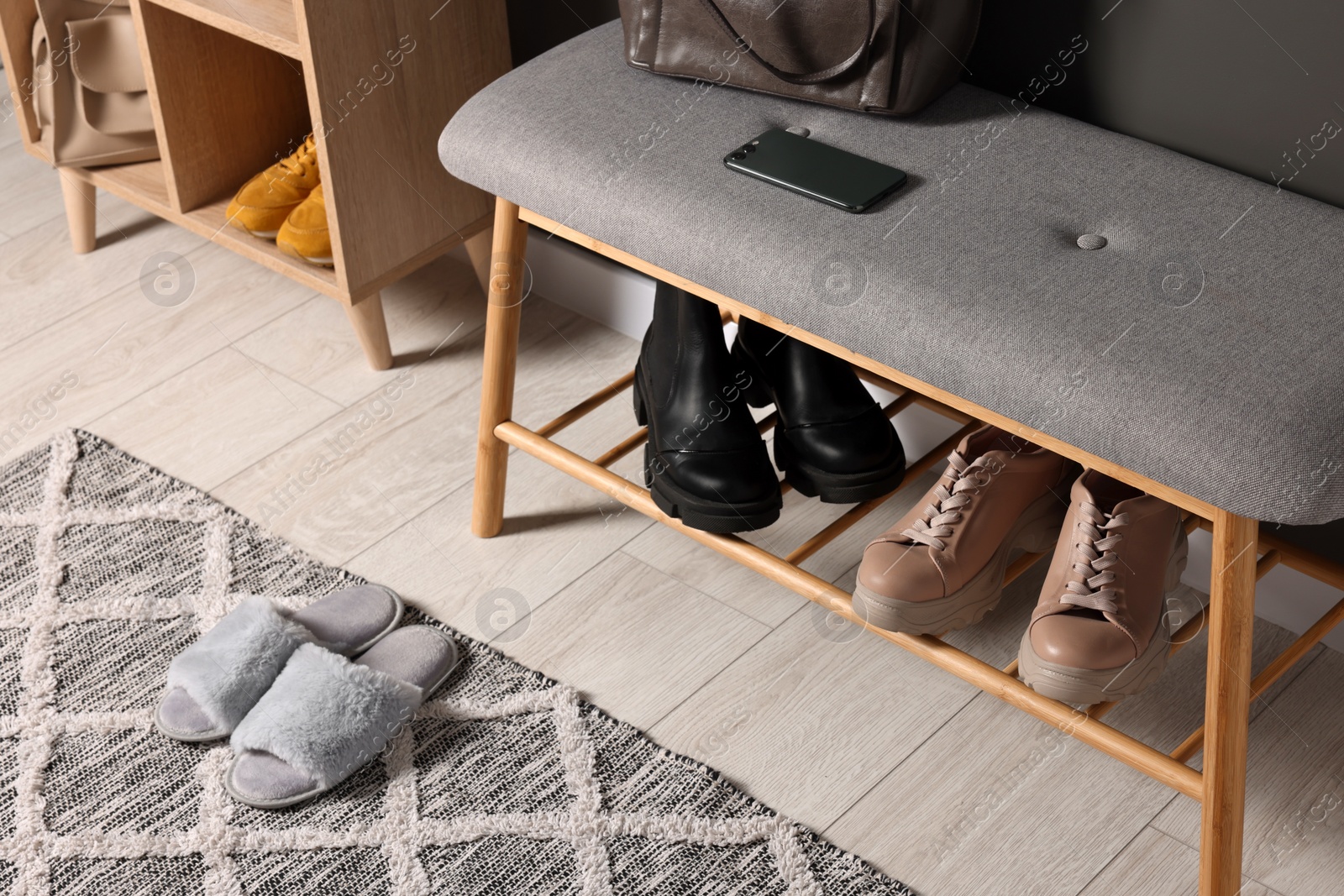 Photo of Shoe storage bench near grey wall in hallway, above view. Interior design