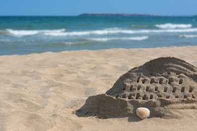 Photo of Beach with sand castle near sea on sunny day. Space for text