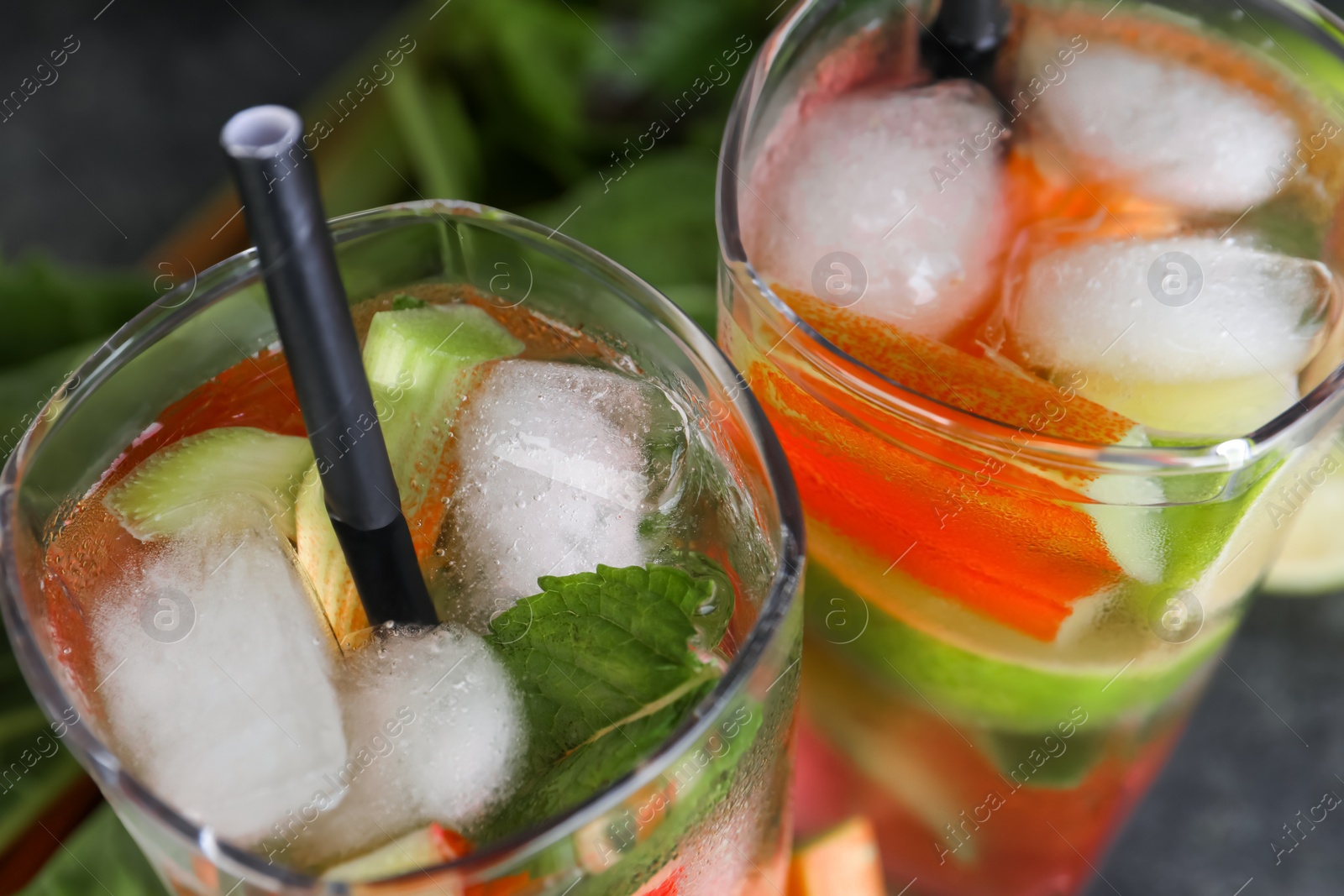 Photo of Tasty rhubarb cocktail with lime on table, closeup view