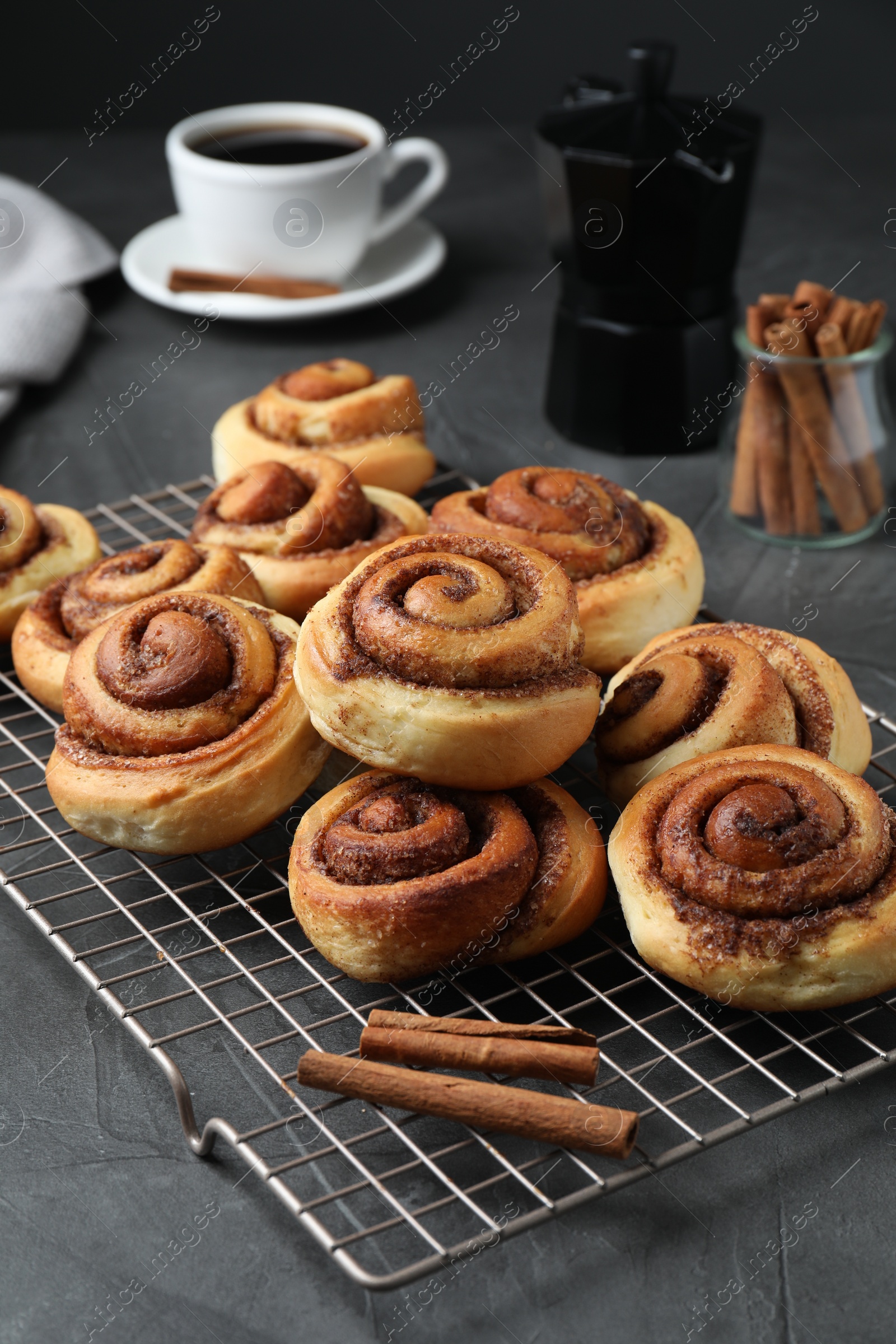 Photo of Tasty cinnamon rolls served on black table