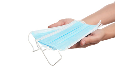 Woman holding disposable face masks on white background, closeup. Protective measures during coronavirus quarantine