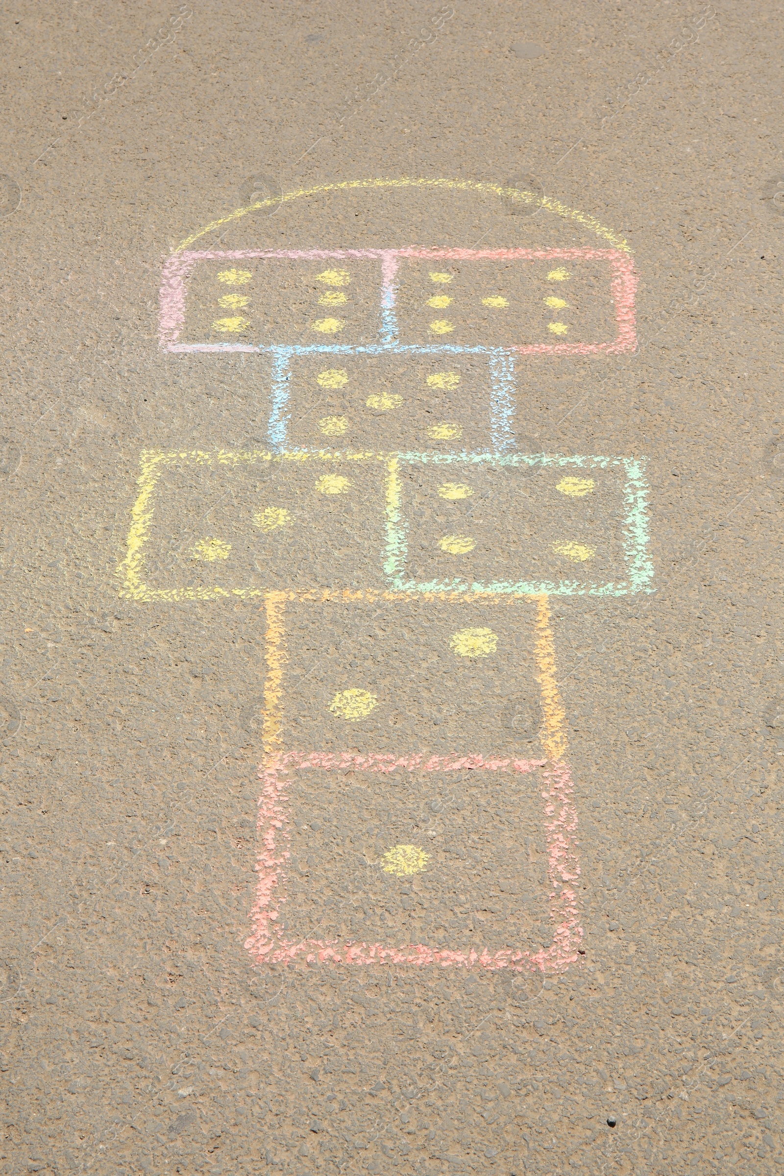 Photo of Hopscotch drawn with colorful chalk on asphalt outdoors